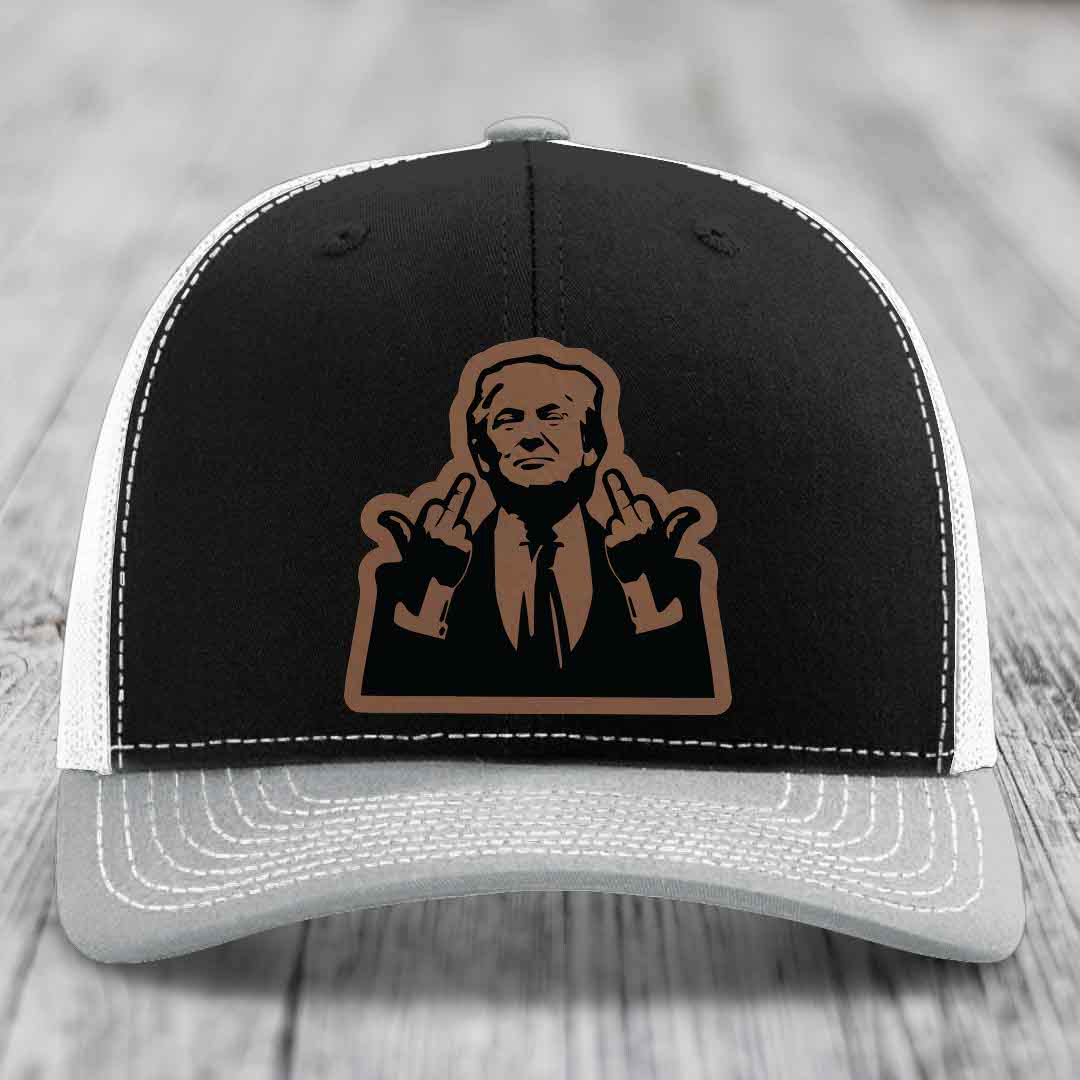 Black and white trucker hat with brown leather patch of man making rude hand gesture.