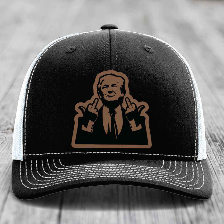 Black trucker hat with white mesh back and stitching, featuring a brown graphic of a man making rude hand gestures.