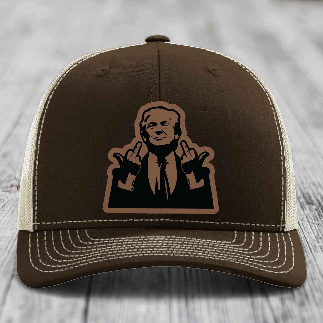 Brown trucker hat with white stitching and a black leatherette patch of a man making hand gestures.