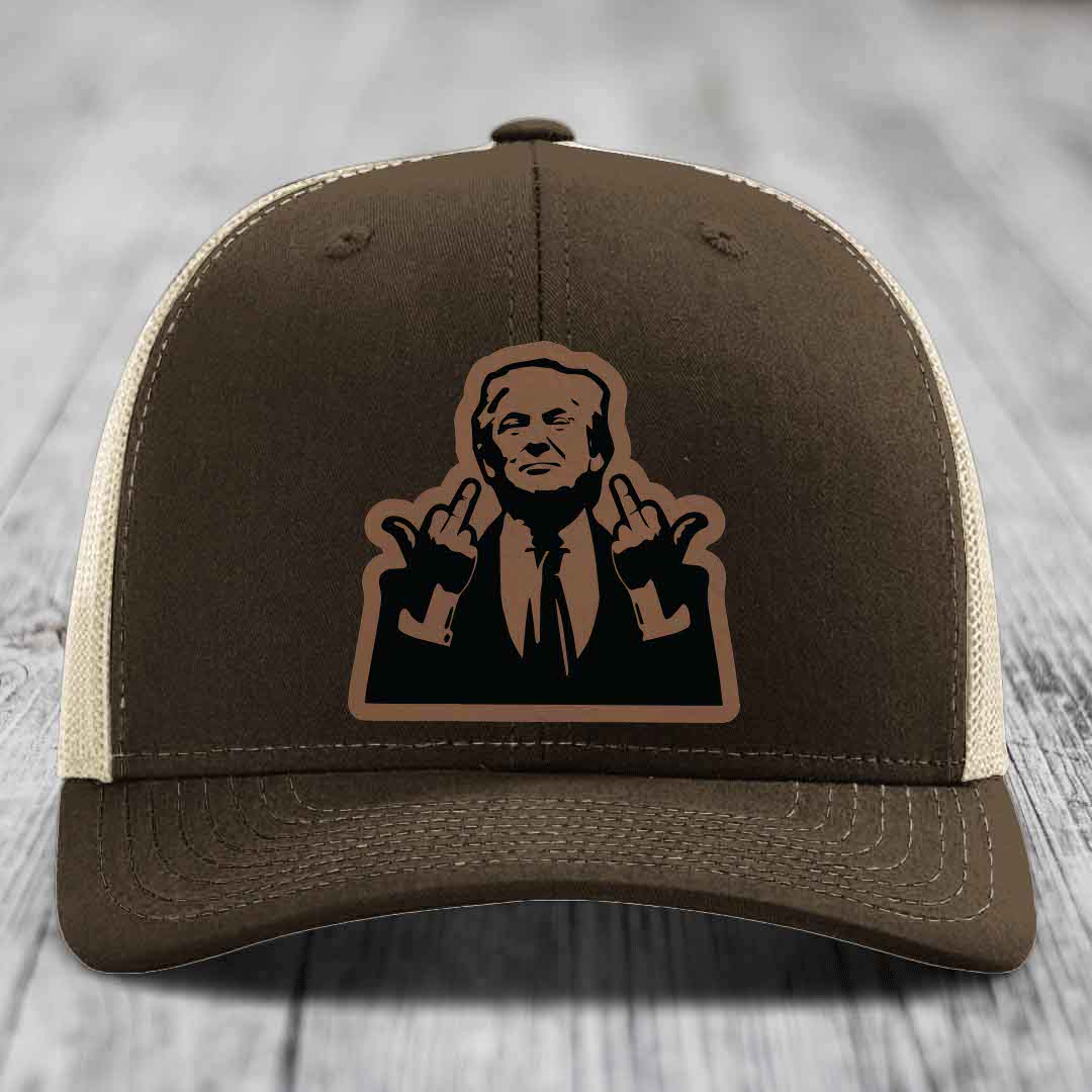 Brown trucker hat with beige mesh back and a black leatherette patch of a man making rude hand gestures.