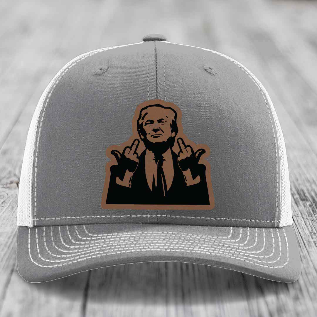 Grey trucker hat with white mesh back and stitched details, featuring a brown leatherette patch of a man making hand gestures.