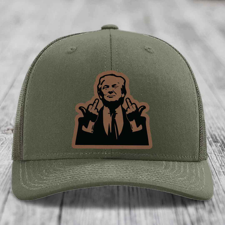 Olive green trucker hat with a brown leather patch showing a man making a hand gesture.