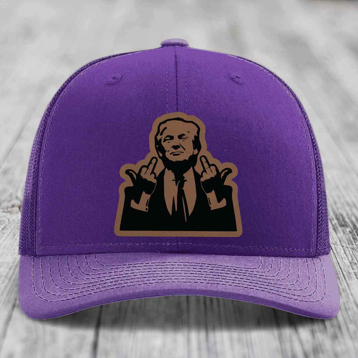 Purple trucker hat with a brown and black graphic patch of a man making hand gestures.