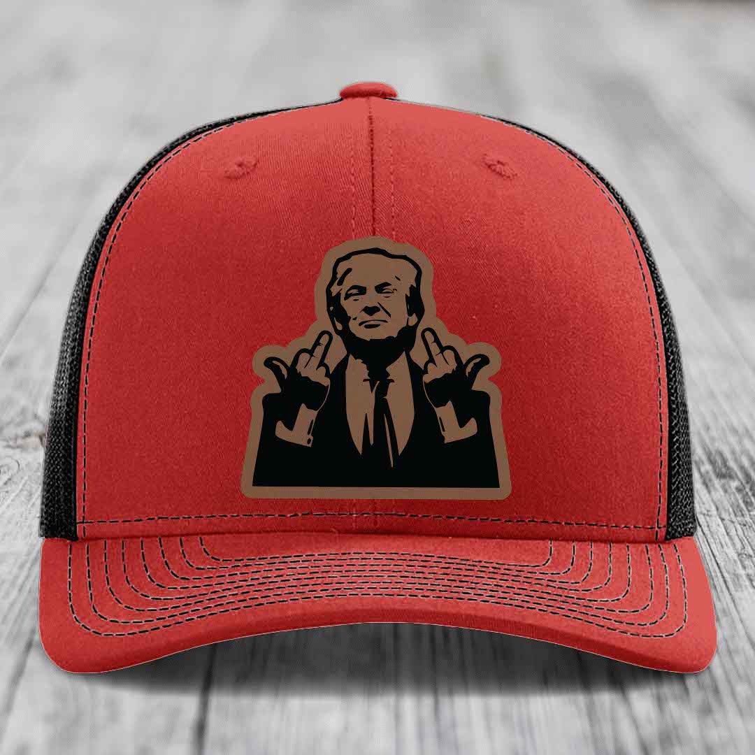Red trucker hat with black mesh back and a brown leather patch of a man making hand gestures.