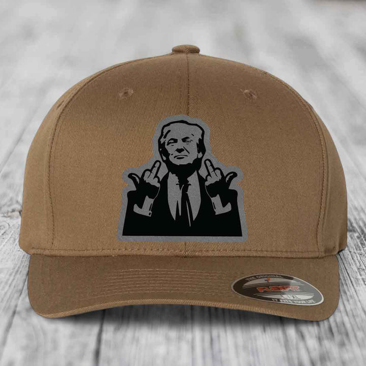 Tan baseball cap with black and grey patch of man making rude hand gesture.