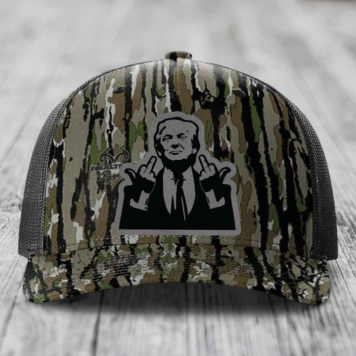 Camouflage trucker hat with black and grey patch of man making rude hand gesture.