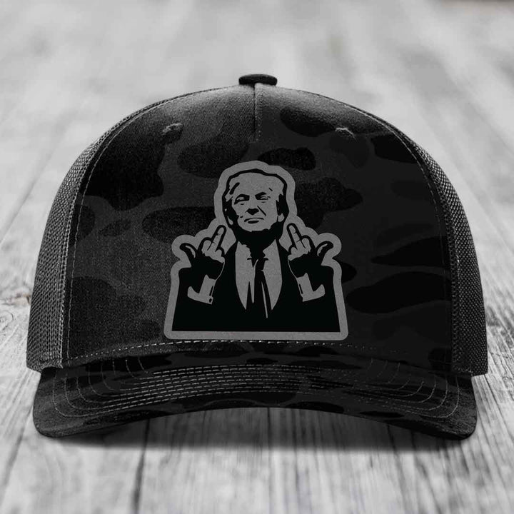 Black camouflage trucker hat with a graphic patch of a man making hand gestures.