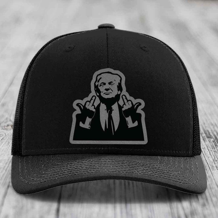 Black trucker hat with gray embroidered patch of a man making hand gestures.