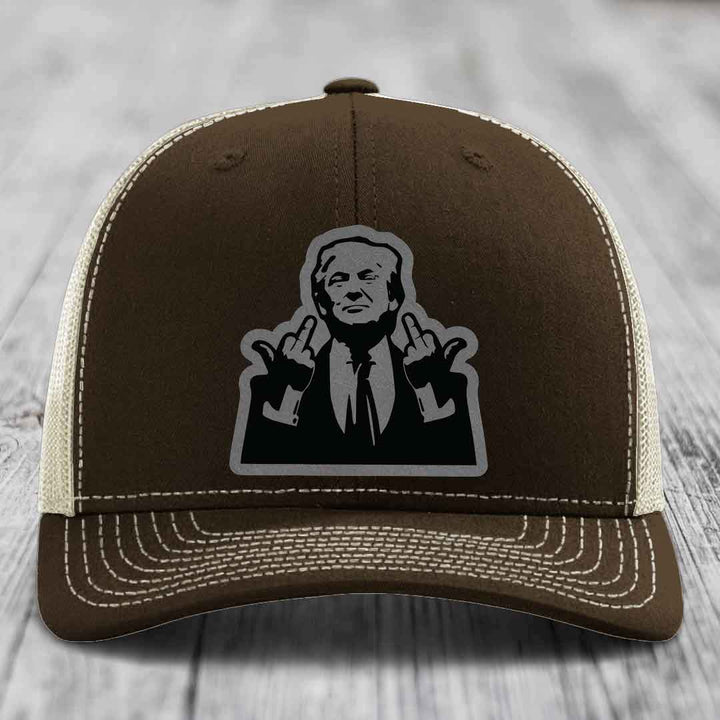 Brown trucker hat with white stitching and a black silhouette patch of a man making hand gestures.