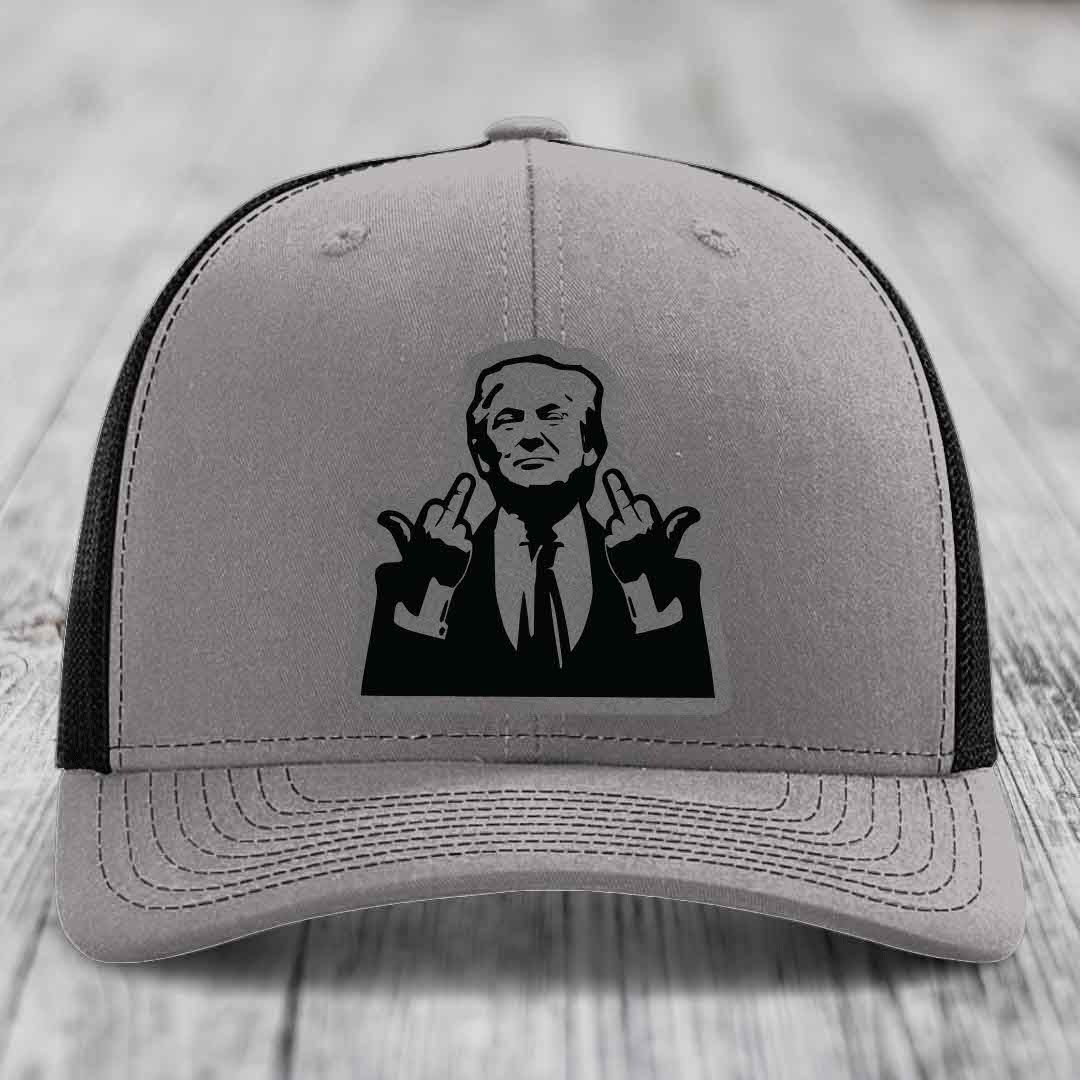 Grey trucker hat with black mesh back and a black leatherette patch of a man making a rude gesture.