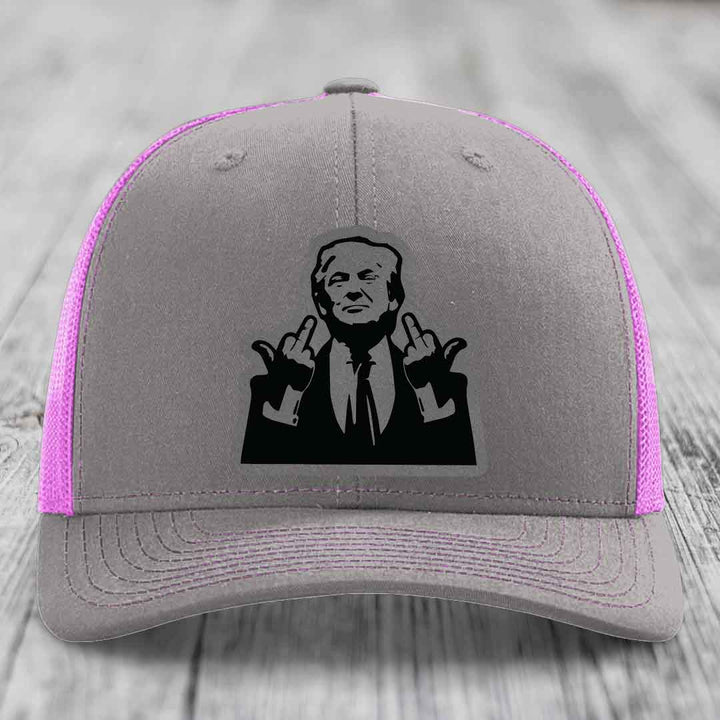 Grey trucker hat with pink mesh sides and a black graphic patch of a man making hand gestures.