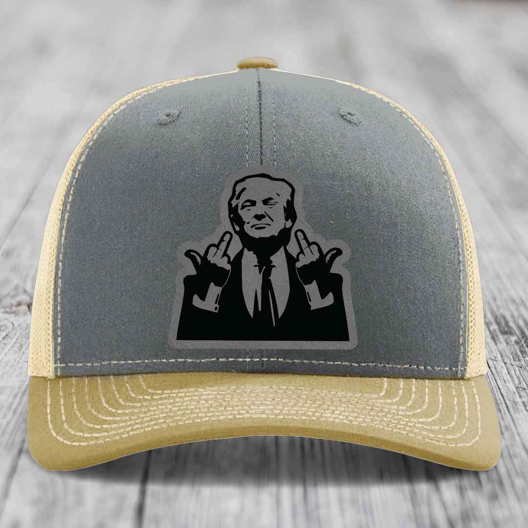 Grey and beige trucker hat with black leather patch of man making rude hand gesture.