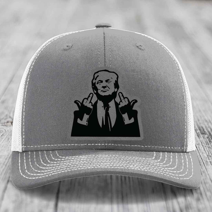 Grey trucker hat with white mesh back and black patch of man giving middle finger gesture.