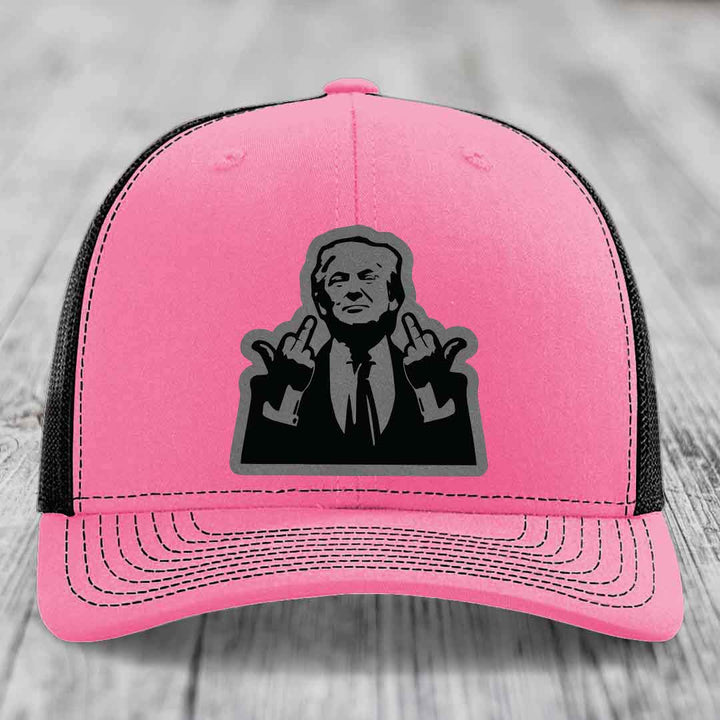 Pink trucker hat with black mesh back and a black graphic patch of a man making hand gestures.