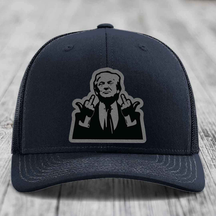 Black trucker hat with gray stitched details and a black-and-gray graphic patch of a man making hand gestures.