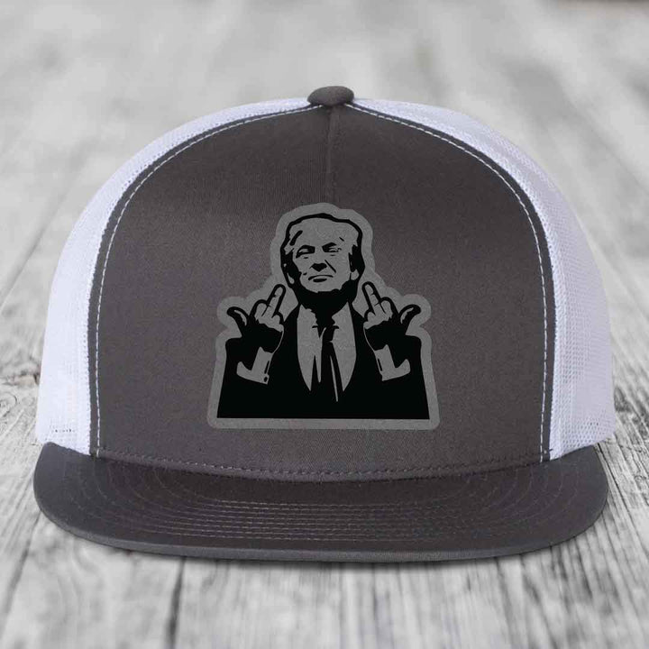 Grey and white trucker hat with black patch of man giving middle finger gesture.