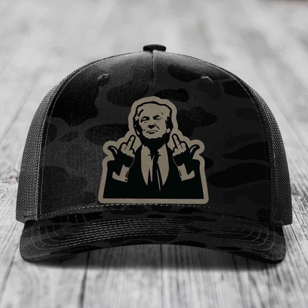 Black camouflage trucker hat with a beige and black patch of a man making rude hand gestures.
