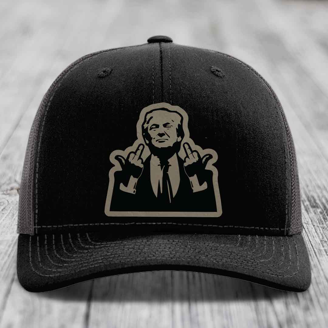 Black trucker hat with beige silhouette patch of a man making rude hand gestures.