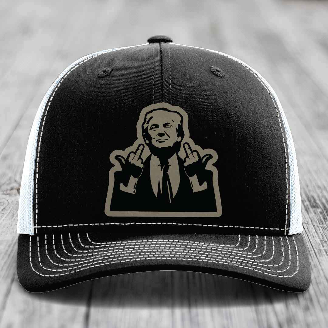 Black trucker hat with white stitching and a beige patch of a man making rude hand gestures.