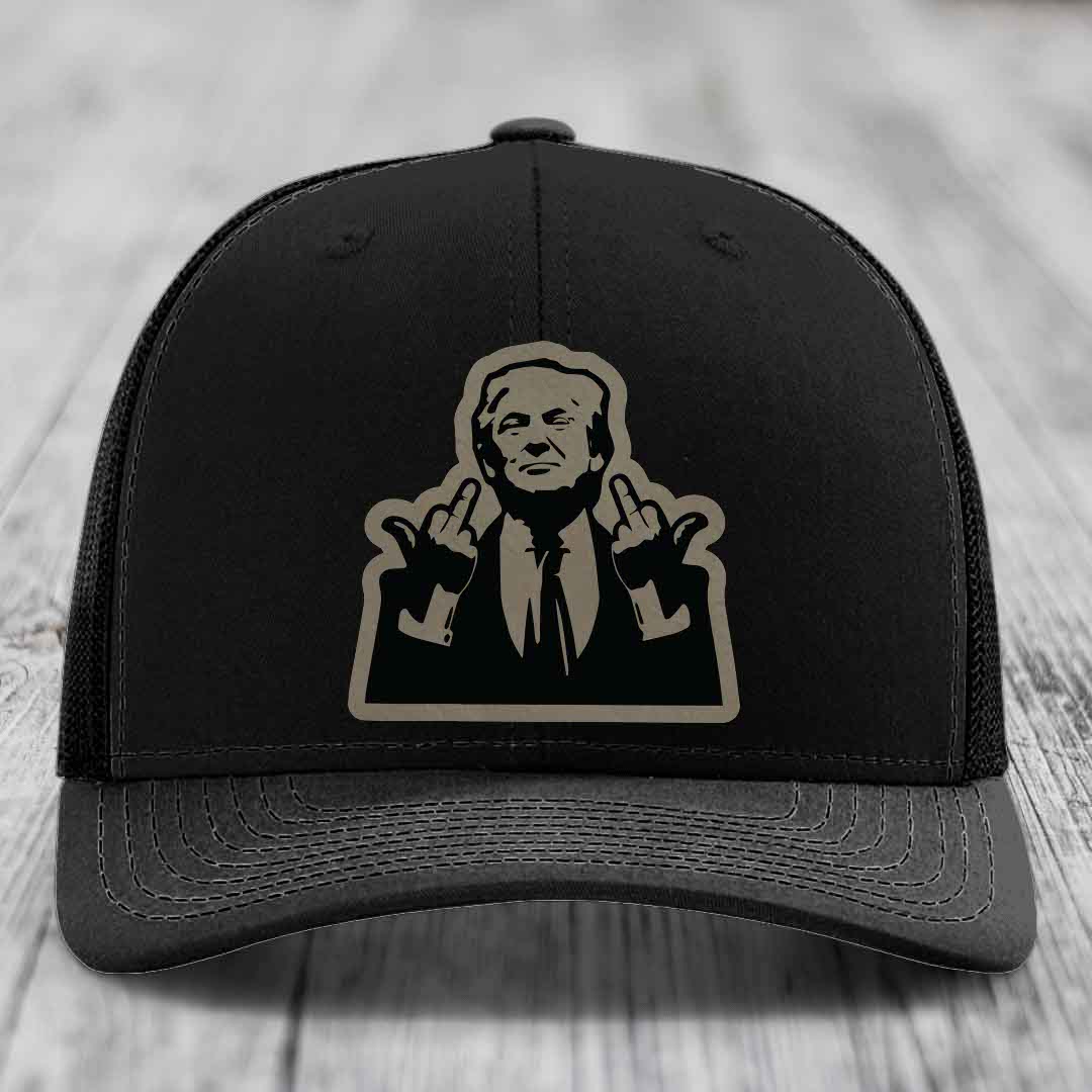 Black trucker hat with beige silhouette patch of a man making rude hand gestures.