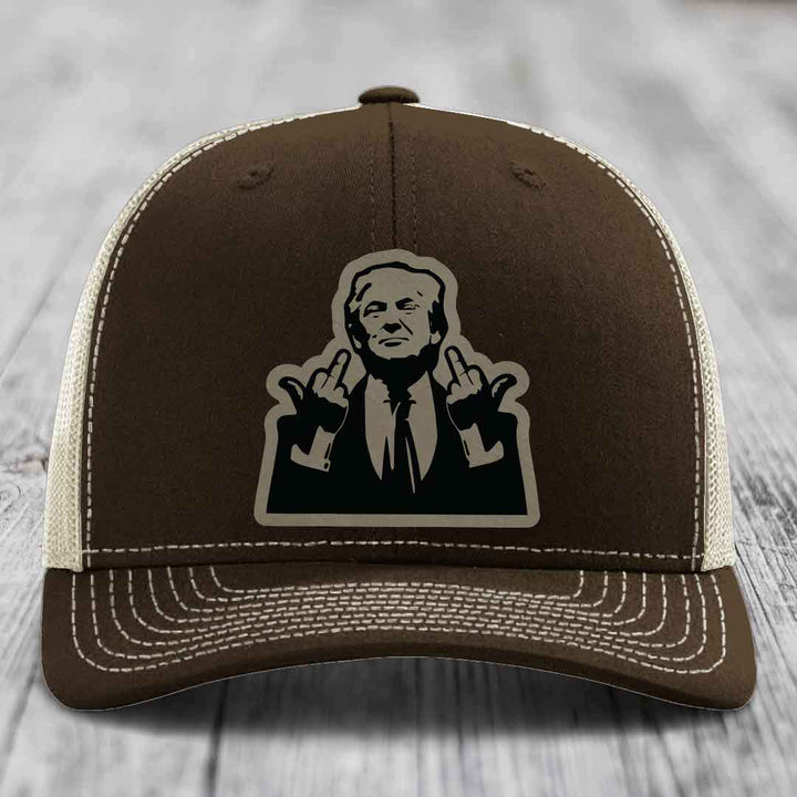 Brown trucker hat with white stitching and a black silhouette patch of a man making hand gestures.