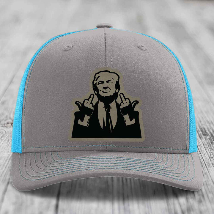 Grey trucker hat with blue mesh sides and a black graphic patch of a man making hand gestures.