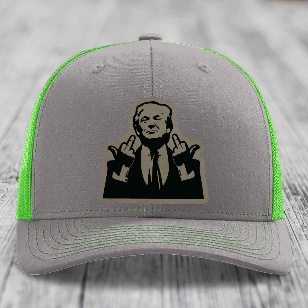 Grey trucker hat with neon green mesh and stitching, featuring a black leatherette patch of a man making hand gestures.