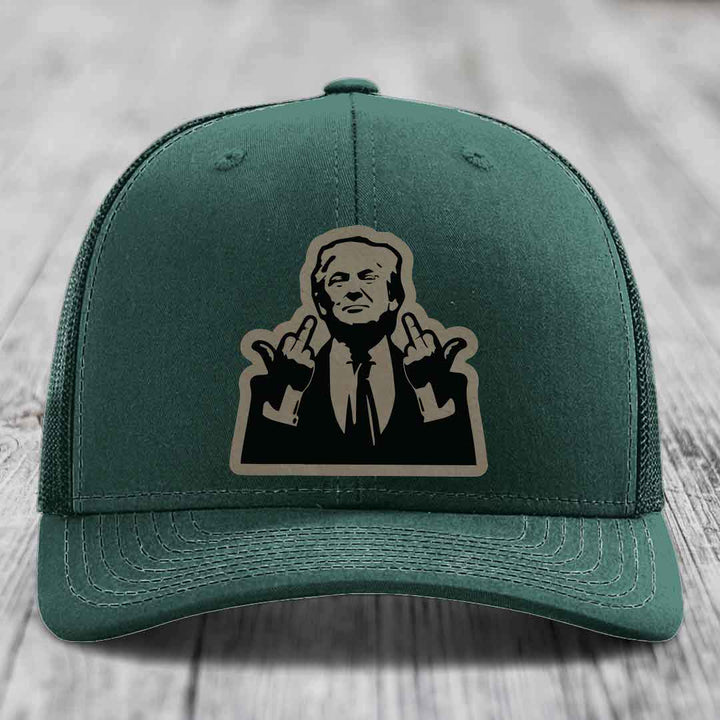 Green trucker hat with black and tan patch of man giving middle finger gesture.