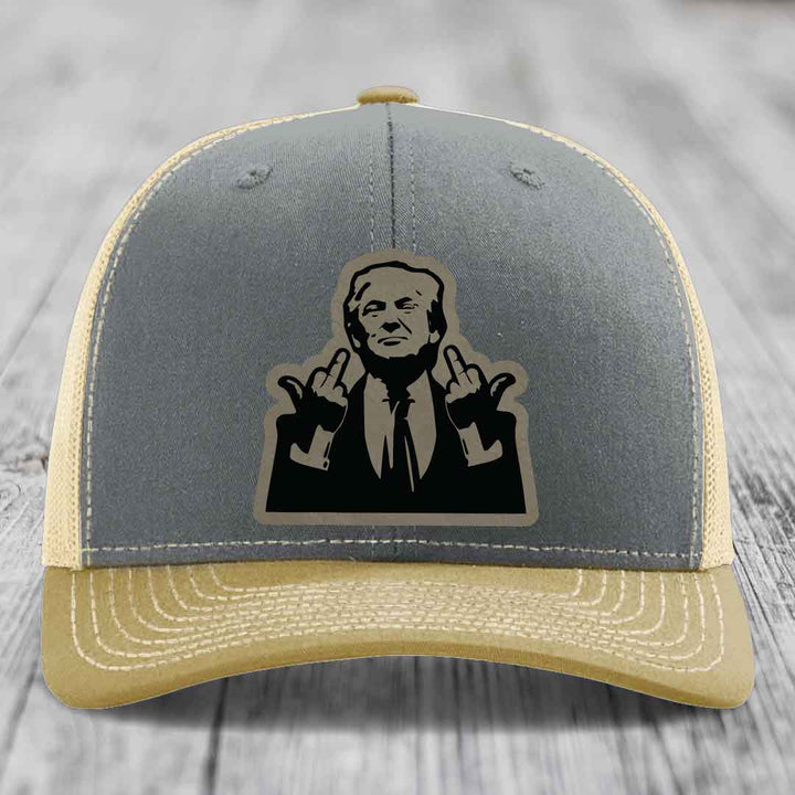Grey and beige trucker hat with black silhouette patch of man making rude hand gestures.