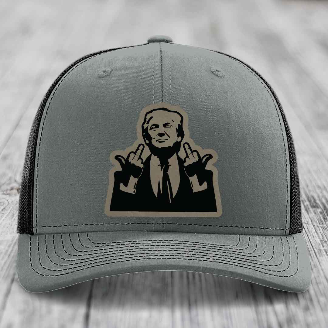 Grey trucker hat with black and tan patch of man giving two middle fingers