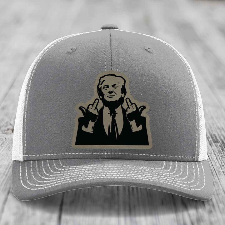Grey trucker hat with white mesh back and stitched details, featuring a black and tan patch of a man making hand gestures.