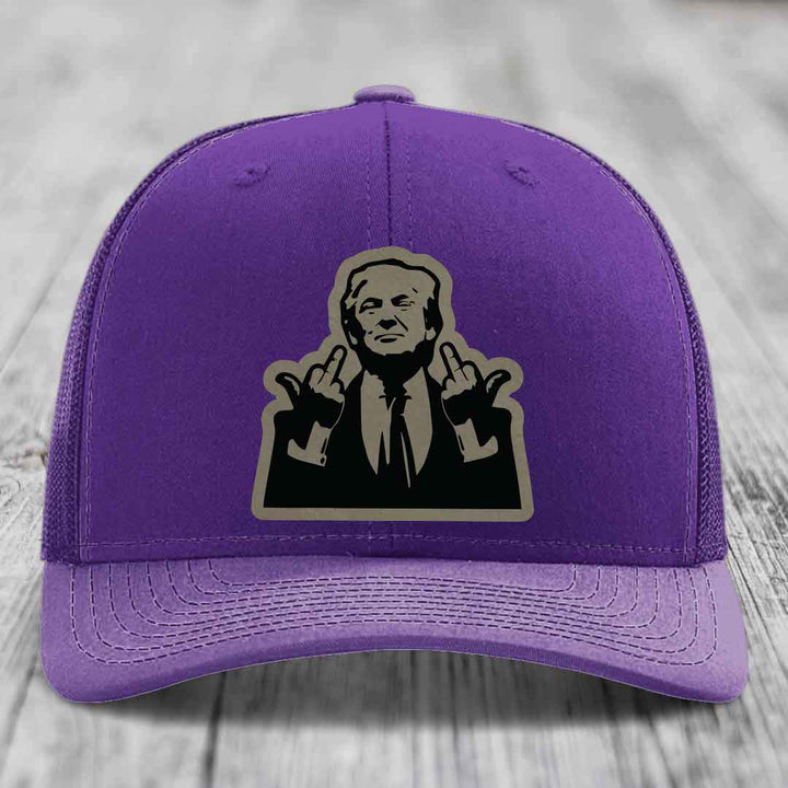 Purple trucker hat with a graphic patch of a man making rude hand gestures.