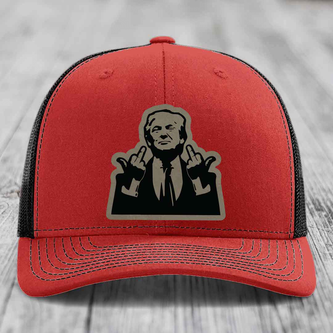 Red trucker hat with black mesh back and a graphic patch of a man making hand gestures.