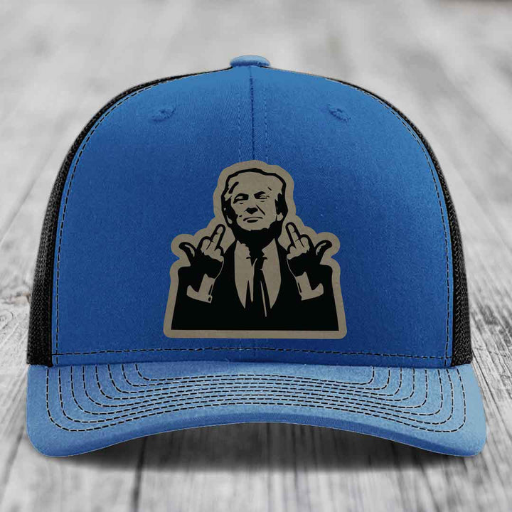Blue trucker hat with black mesh back and a beige leather patch of a man making hand gestures.