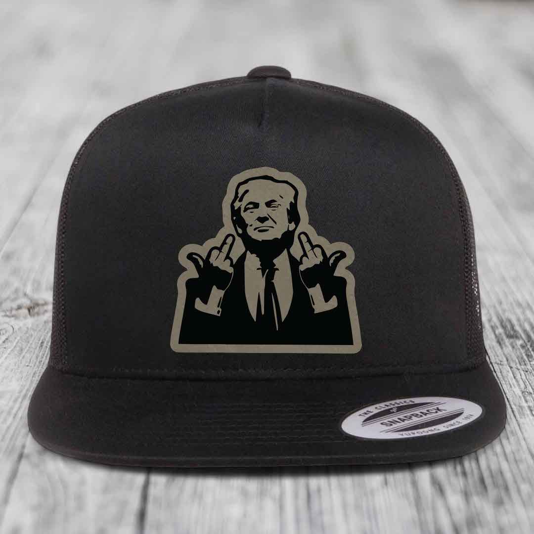 Black snapback trucker hat with beige and black graphic patch of a man making hand gestures.