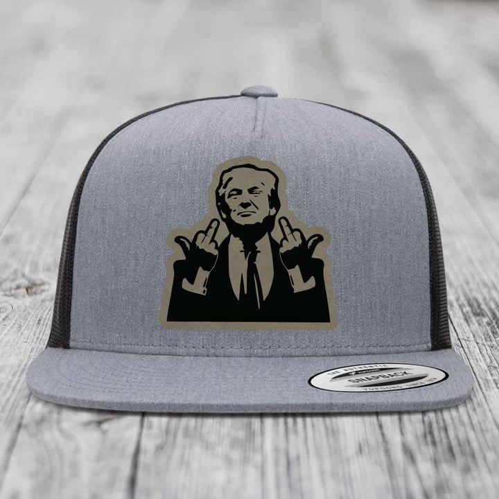 Grey trucker hat with black and tan patch of man giving middle finger, Flexfit brand label visible.