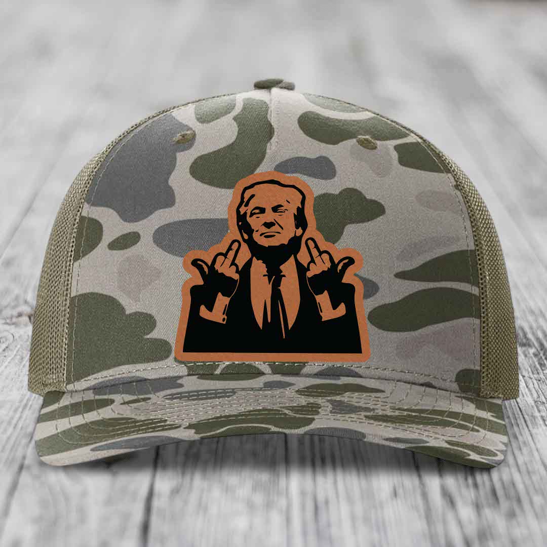 Camouflage trucker hat with a leather patch of a man making rude hand gestures.