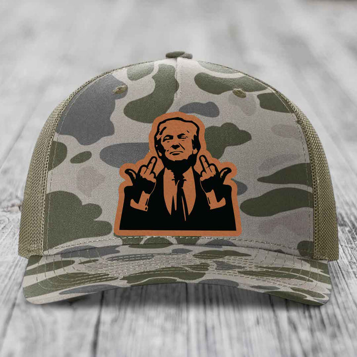 Camouflage trucker hat with a leather patch of a man making rude hand gestures.