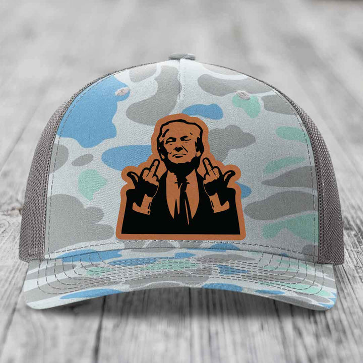 Camouflage trucker hat with a brown leather patch featuring a cartoon of a man giving two middle fingers.