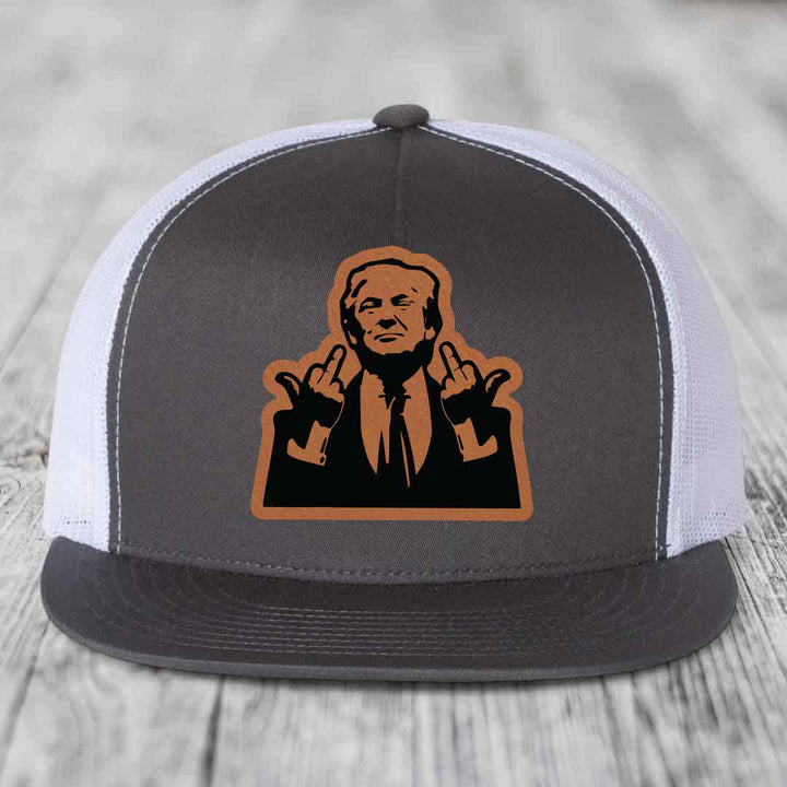 Grey and white trucker hat with a brown leather patch of a man making rude hand gestures.