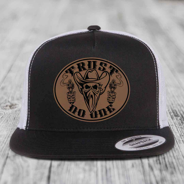 Black and white trucker hat with brown leather patch featuring &