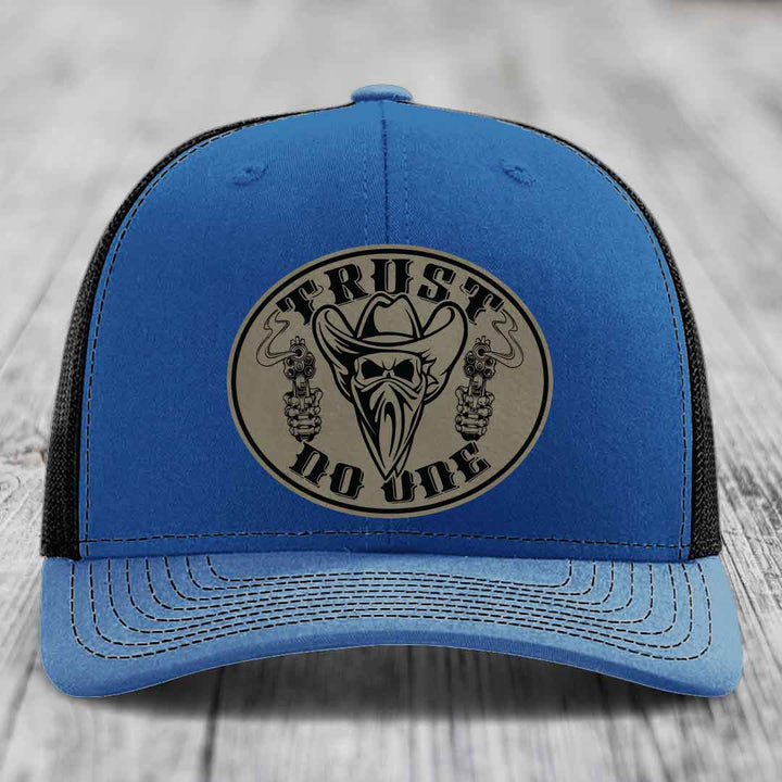 Blue trucker hat with a circular leather patch featuring &