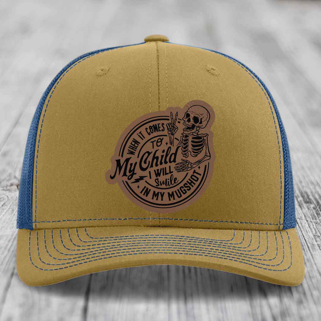 Tan and blue trucker hat with a skeleton patch reading &