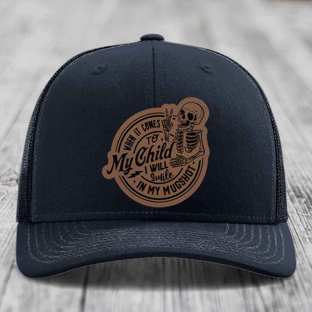 Black trucker hat with brown leather patch featuring skeleton and text &