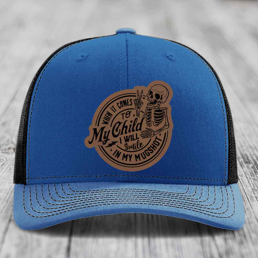 Blue trucker hat with brown leather patch featuring skeleton and text &