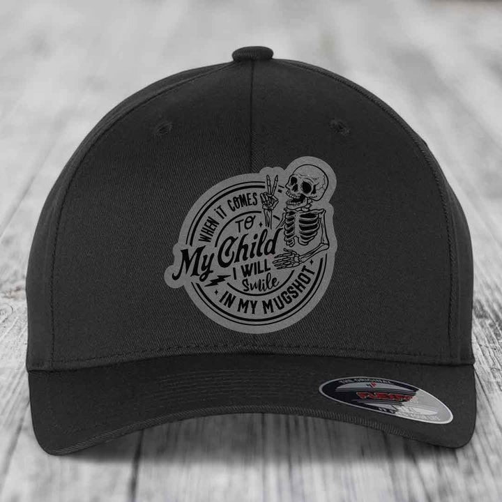 Black baseball cap with grey circular patch featuring skeleton holding peace sign and text &