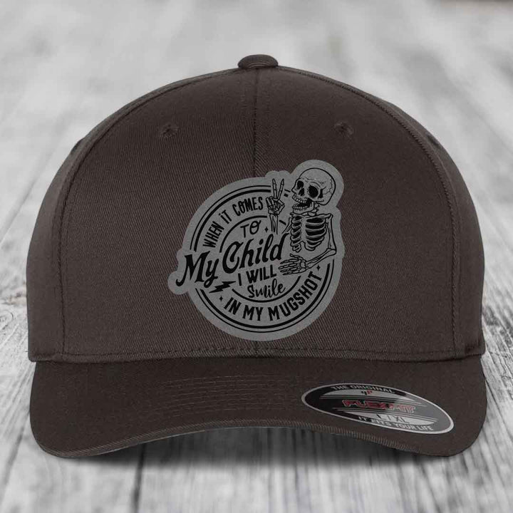 Dark brown Flexfit hat with a skeleton patch reading &