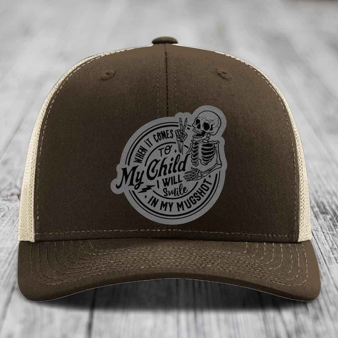 Brown trucker hat with grey skull patch reading &