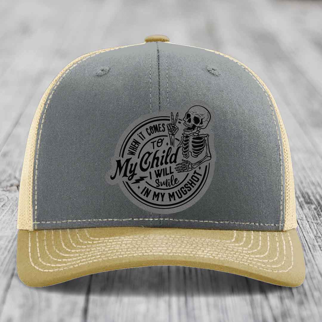 Grey and beige trucker hat with skull patch reading &
