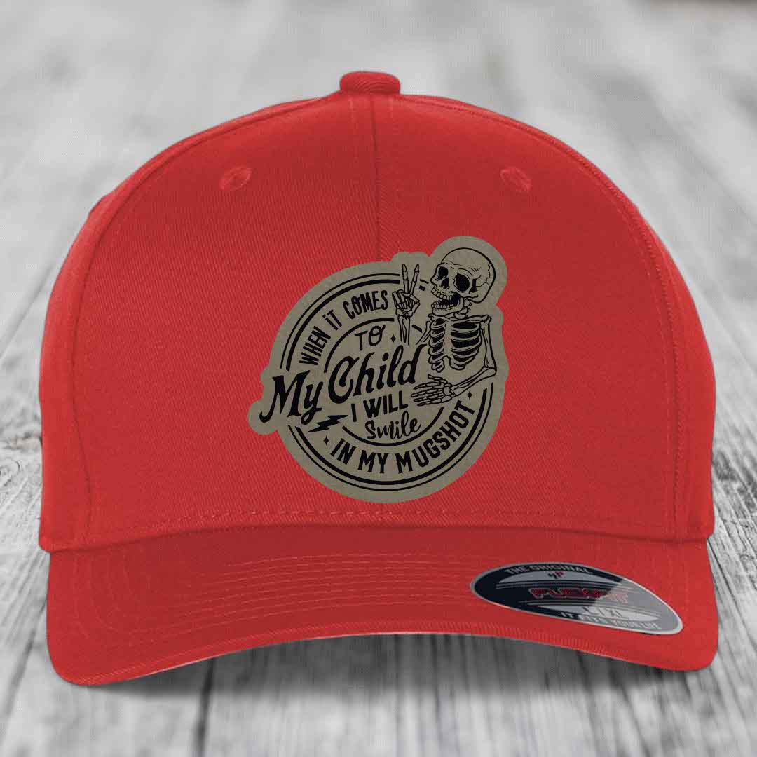 Red baseball cap with a circular patch featuring a skeleton making a peace sign and the text &